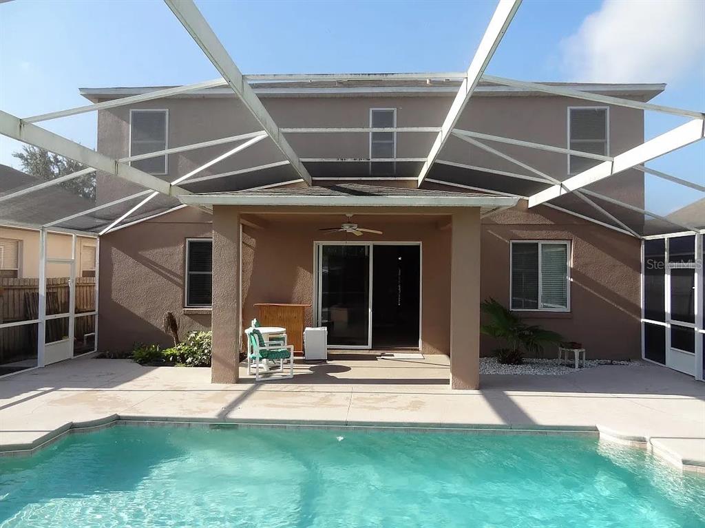 A two-story house exterior features a screened-in pool deck with a covered patio area — 4025 SHAWN CIRCLE, ORLANDO, FL