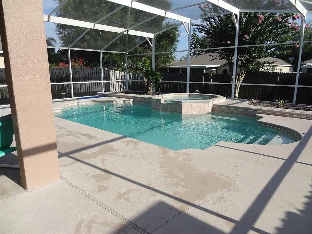 A screened-in swimming pool and spa with a concrete deck and a wooden privacy fence — 4025 SHAWN CIRCLE, ORLANDO, FL