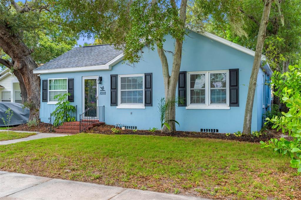 A light blue single-story house with black shutters and a small brick front porch — 1010 OSAGE STREET, CLEARWATER, FL