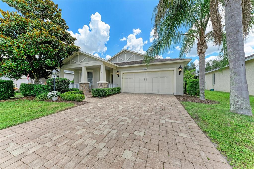 A single-story house with a paved driveway, a two-car garage, and a covered front porch — 11960 FOREST PARK CIRCLE, BRADENTON, FL