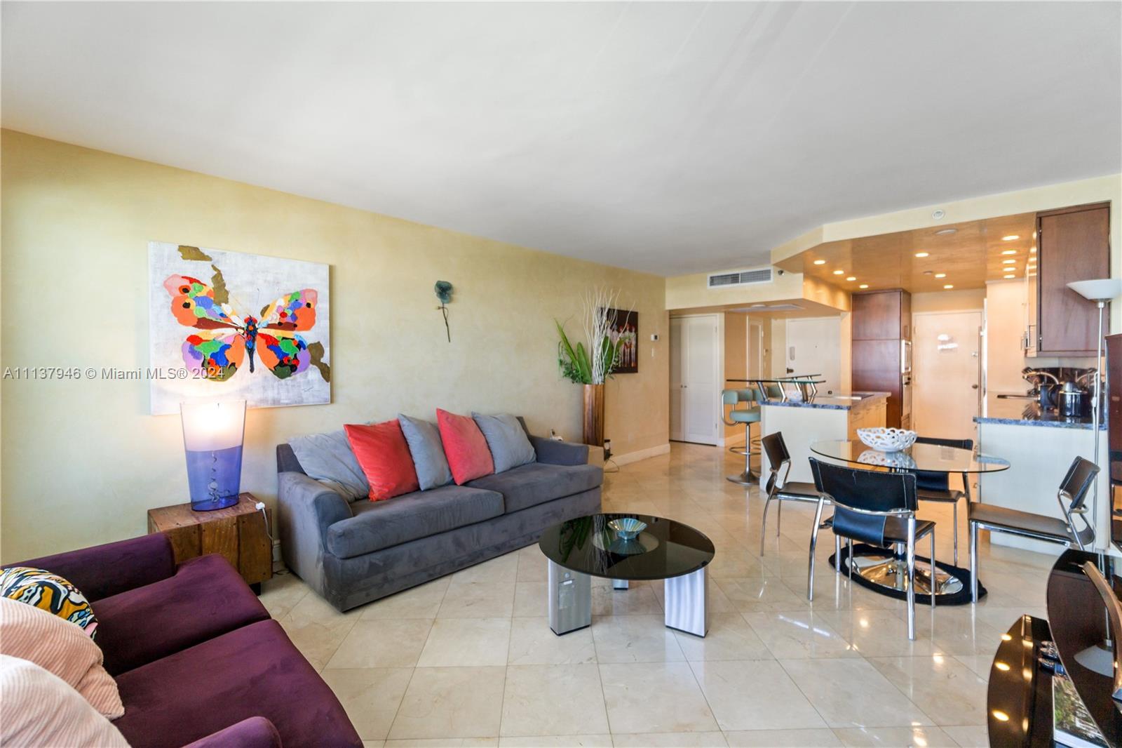 A living room features a grey sofa, a purple couch, and an adjacent open kitchen — 100 Lincoln Rd # 1533, Miami Beach FL 33139, MIAMI BEACH, FL