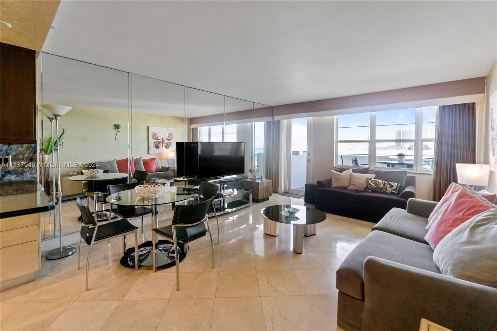A living and dining area features mirrored walls, tile flooring, and a balcony with ocean views — 100 Lincoln Rd # 1533, Miami Beach FL 33139, MIAMI BEACH, FL