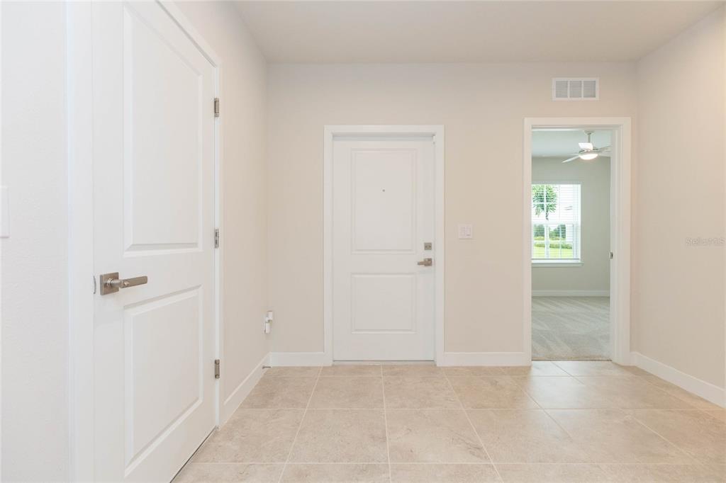 An entryway with light tile flooring, white walls, and three white interior doors — 2371 SCENIC PARK LOOP, WIMAUMA, FL