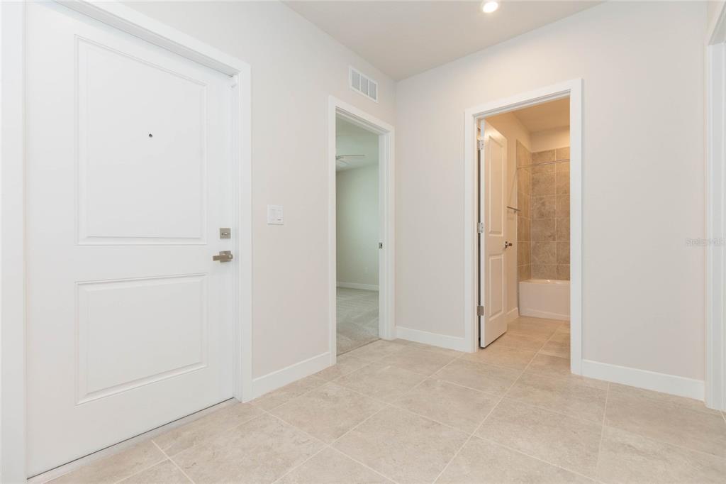A tiled entryway features a white front door, an interior doorway, and a tiled bathroom — 2371 SCENIC PARK LOOP, WIMAUMA, FL