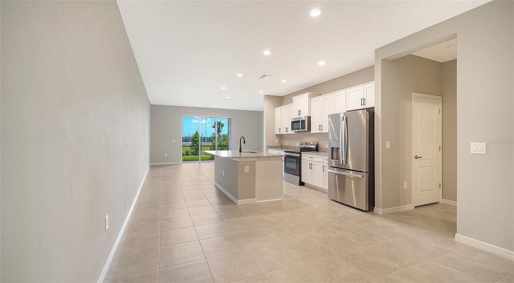 A modern kitchen with white cabinets, stainless steel appliances, and a central island — 2365 WASHINGTON PALM COURT, BRADENTON, FL