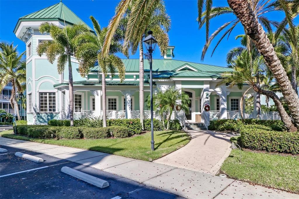 A swimming pool surrounded by a paved deck, palm trees, and multi-story residential buildings — 5123 MELBOURNE STREET UNIT D106, PORT CHARLOTTE, FL