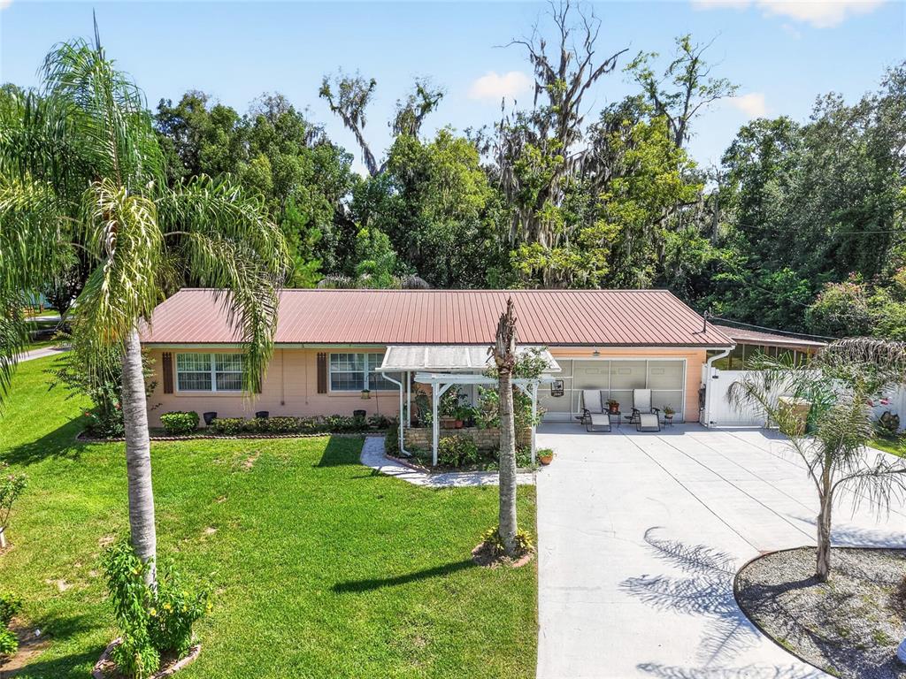 A single-story house with a metal roof, a front porch, and a concrete driveway — 2840 SE 2ND STREET, OCALA, FL