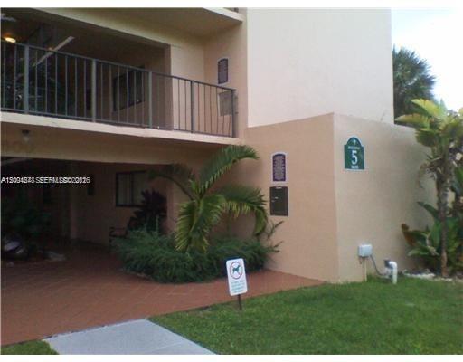 An exterior view of a two-story apartment building with a covered walkway and landscaping — 8600 SW 133rd Ave Rd # 413, Miami FL 33183, MIAMI, FL