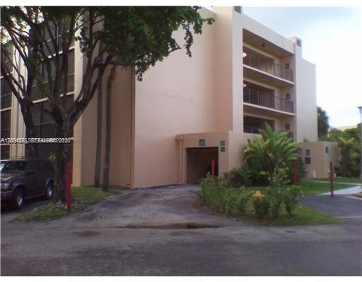 A multi-story beige apartment building features a covered ground-level entrance and balconies with railings — 8600 SW 133rd Ave Rd # 413, Miami FL 33183, MIAMI, FL