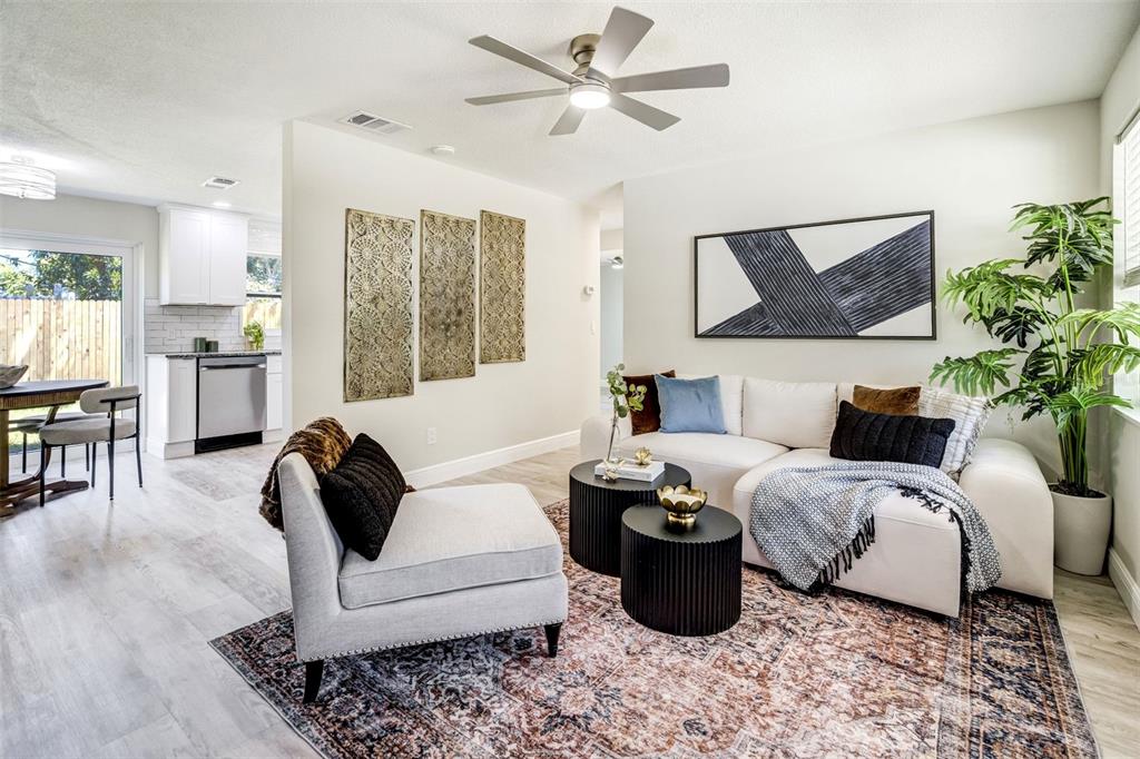 A living room with a white sectional, patterned rug, and an adjacent kitchen area — 3579 POCAHONTAS DRIVE, LARGO, FL