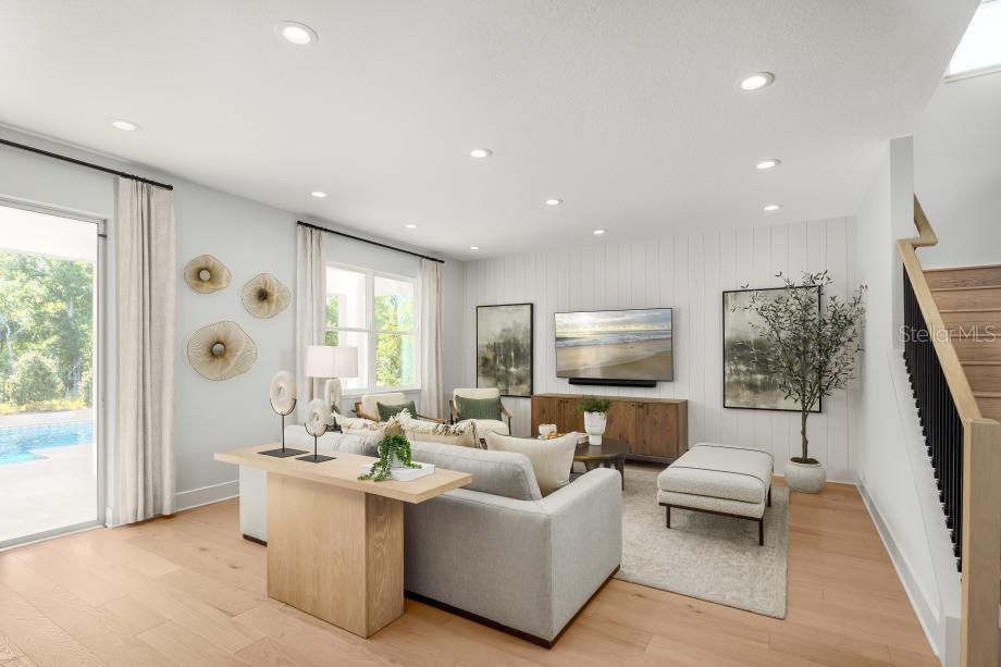 A living room features light wood floors, a shiplap accent wall, and a staircase — 8031 TIMBERWOOD LANE, ORLANDO, FL