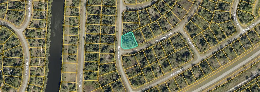 This is an aerial map showing a vacant, wooded residential lot highlighted in light blue — NOME AVENUE, NORTH PORT, FL