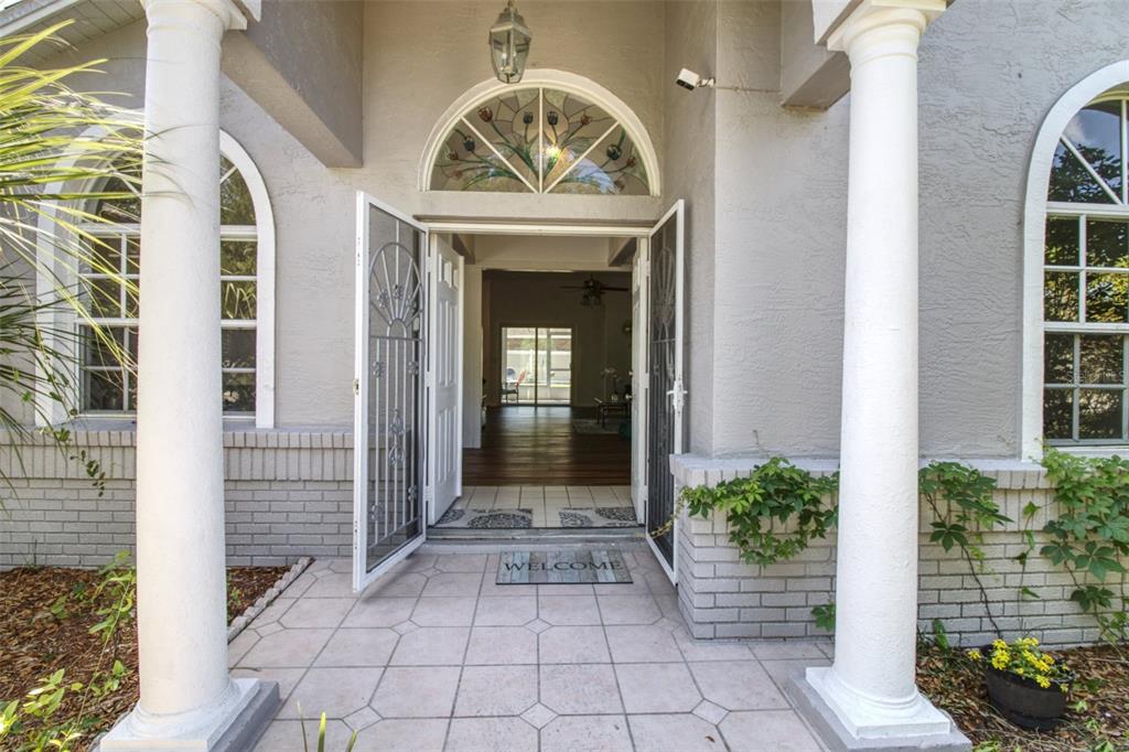 A gray house exterior features a white two-car garage door and a paved driveway — 2 SEAGIRT COURT, PALM COAST, FL