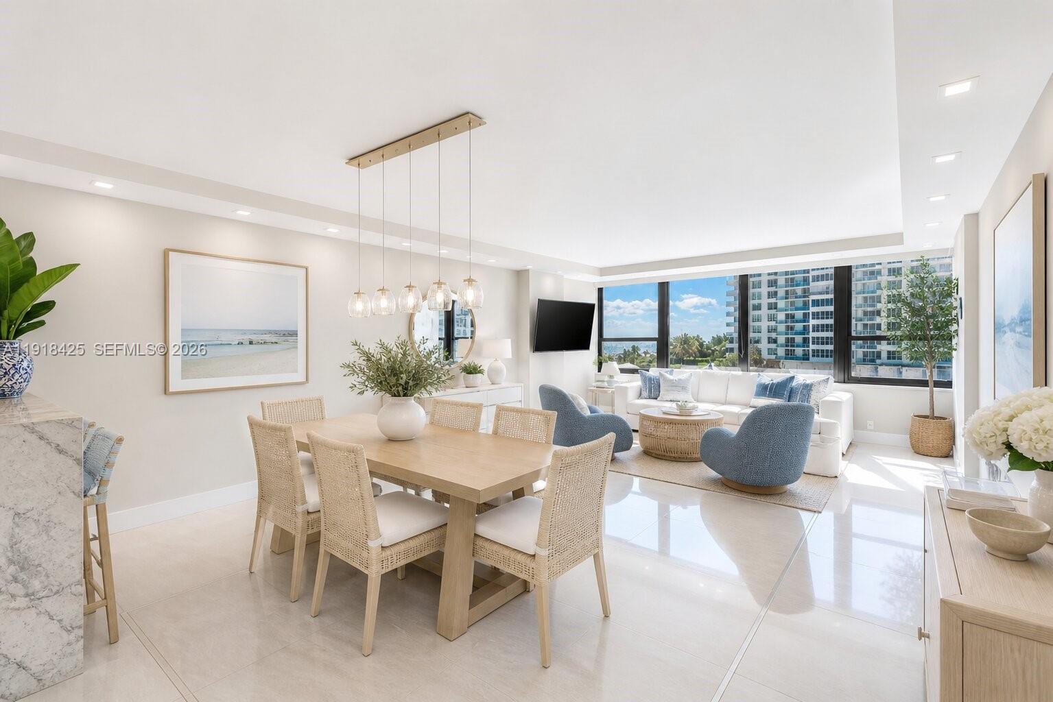 A bright, open-concept living and dining area features light wood furniture and floor-to-ceiling windows — 5225 Collins Ave # 603, Miami Beach FL 33140, MIAMI BEACH, FL