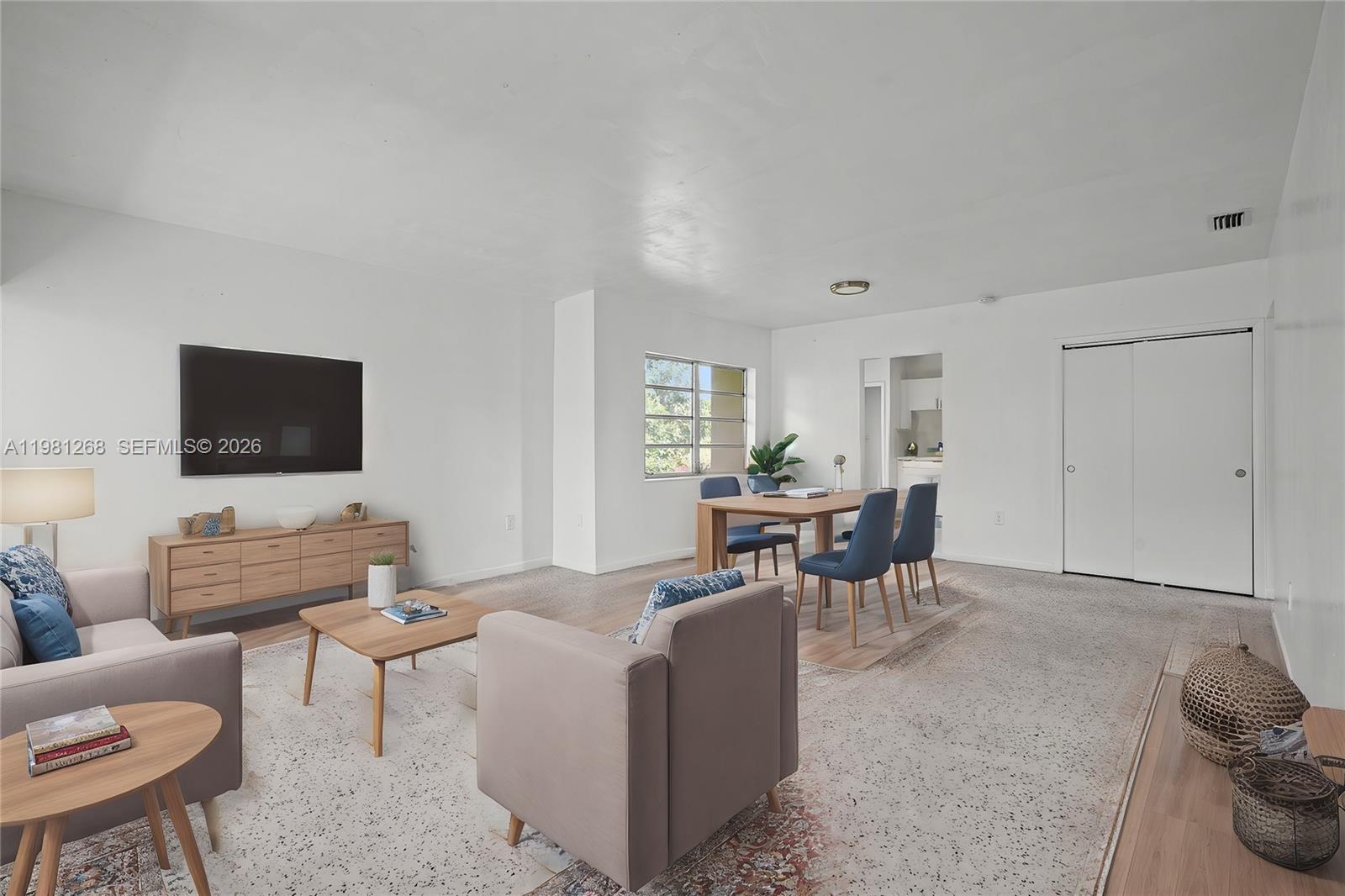 A living and dining area features white walls, light-colored furniture, and a patterned area rug — 11330 Peachtree Dr, Miami FL 33161, MIAMI, FL