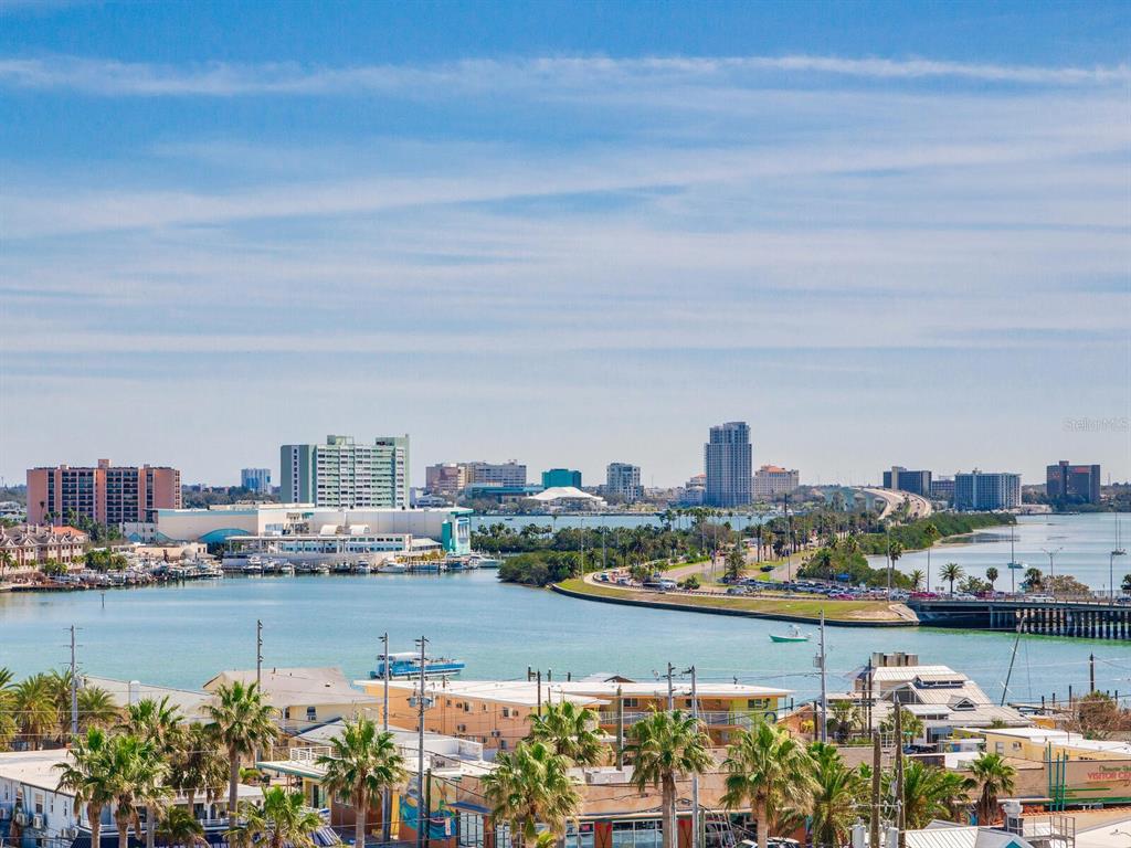 A high-angle view of a coastal city skyline with a bridge, water, and palm trees — 11 SAN MARCO STREET UNIT 807, CLEARWATER BEACH, FL