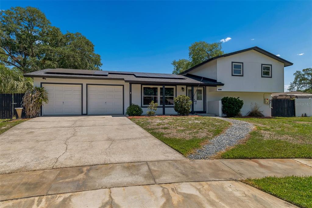 A two-story house with a two-car garage, solar panels, and a gravel walkway — 7111 GATEWAY COURT, TAMPA, FL