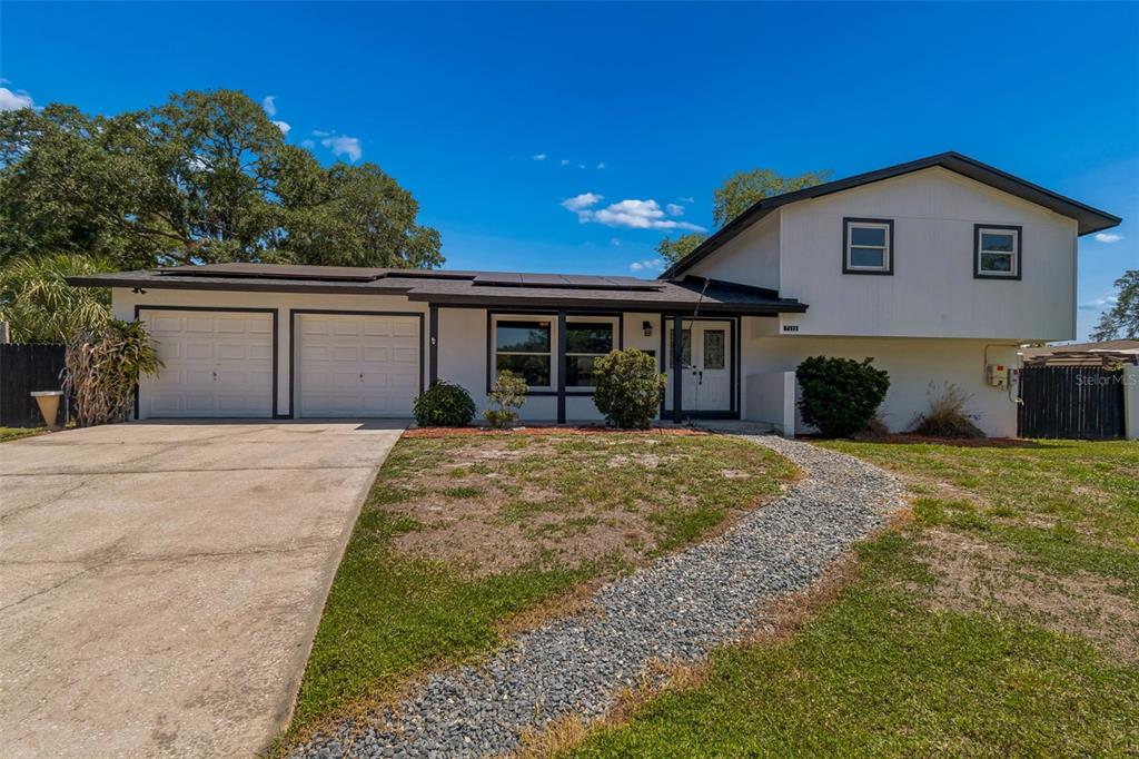 A two-story house with a two-car garage, white siding, and a gravel walkway — 7111 GATEWAY COURT, TAMPA, FL