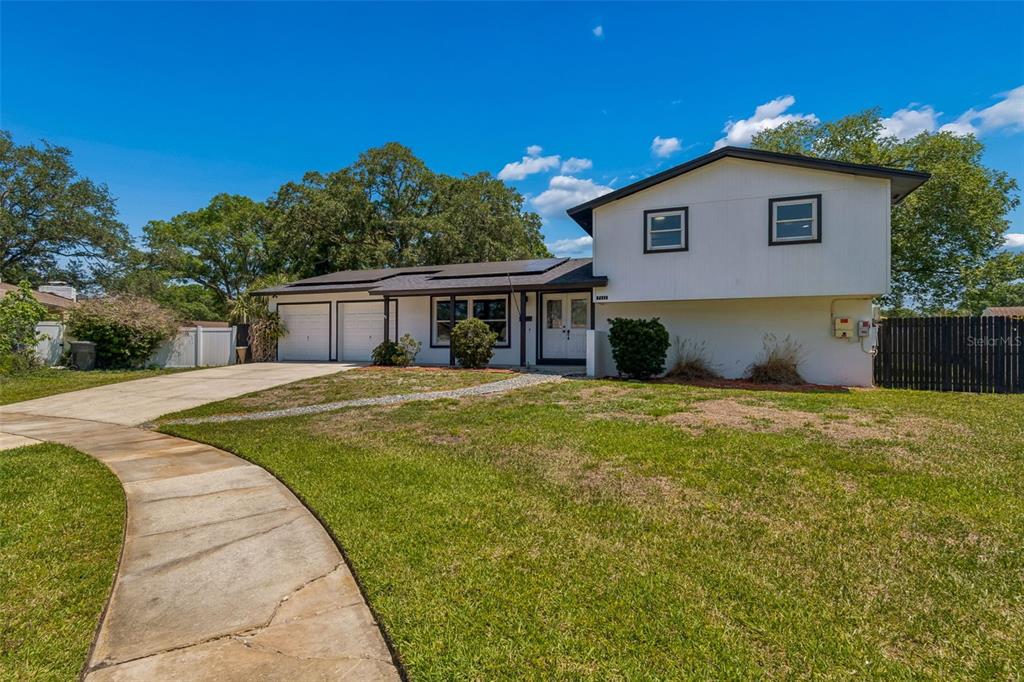 A two-story house with a white exterior, a two-car garage, and a curved concrete walkway — 7111 GATEWAY COURT, TAMPA, FL