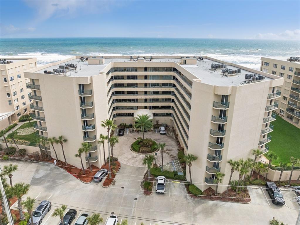An aerial view of a multi-story beachfront condominium building with a central circular driveway — 4555 S ATLANTIC AVENUE UNIT 4506, PONCE INLET, FL