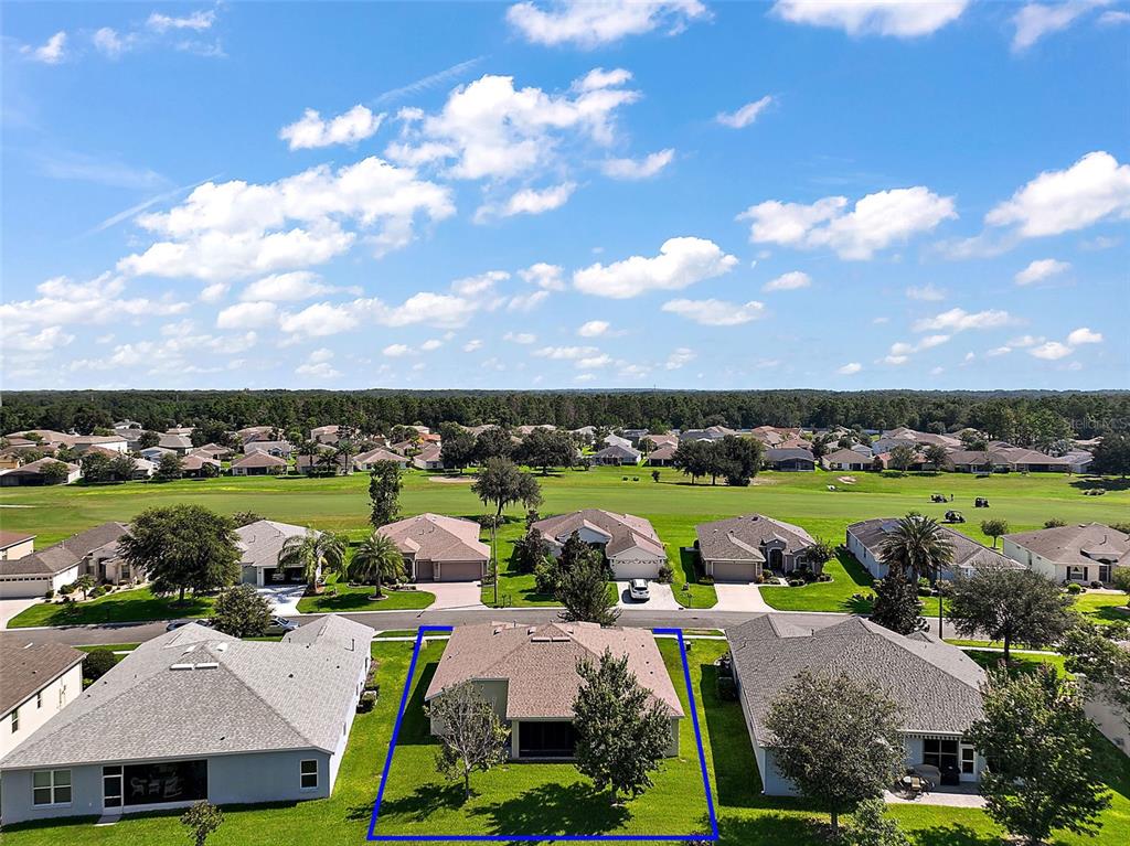 An aerial view shows a single-story house with a blue outline on a golf course — 26860 WHITE PLAINS WAY, LEESBURG, FL
