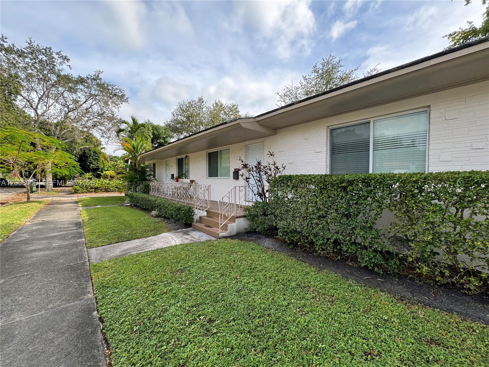 A single-story white brick building features a front porch with metal railings and landscaping — 4 NE 47th St, Miami FL 33137, MIAMI, FL