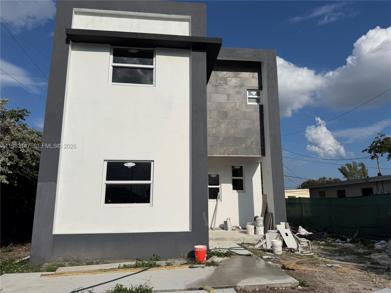 A modern two-story house exterior features white walls, dark gray trim, and stone-tiled accents — 850 NW 18th Ave, Pompano Beach FL 33069, POMPANO BEACH, FL