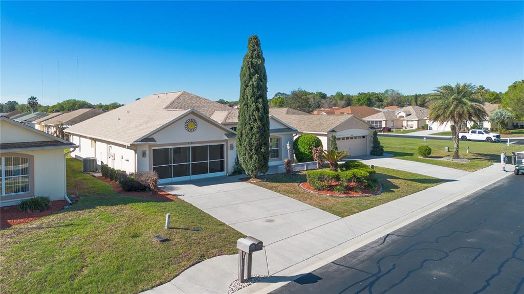 An aerial view shows a suburban house with a screened garage and a tall cypress tree — 4486 N LAKE VISTA TRAIL, HERNANDO, FL