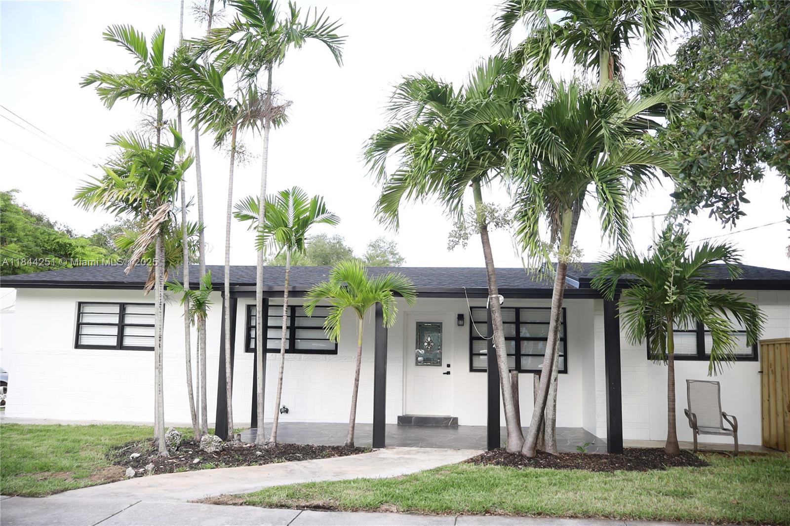 A single-story white house with black trim and palm trees in the front yard — 3955 SW 69th Ave, Miami FL 33155, MIAMI, FL
