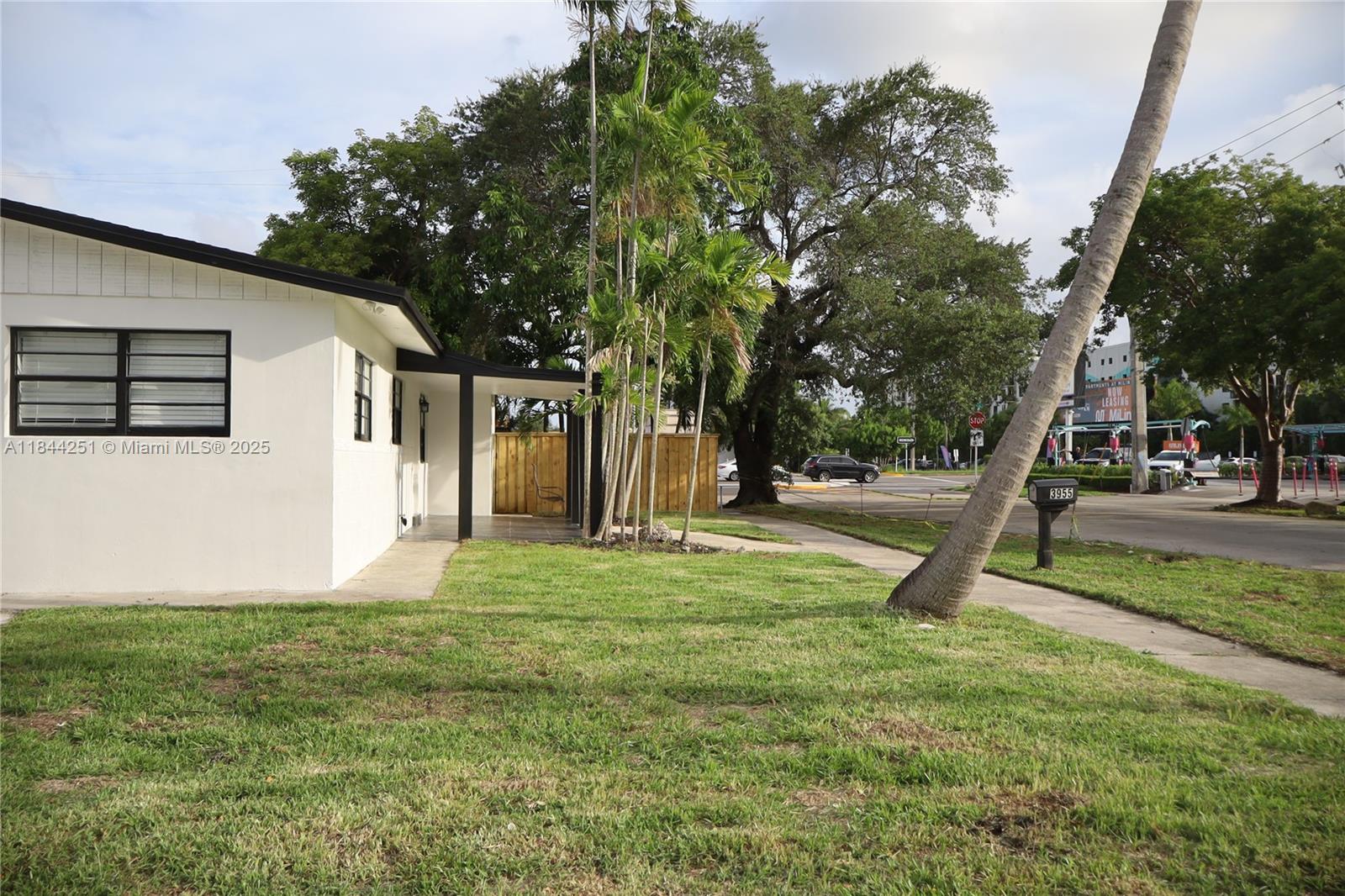 A white house with a black-trimmed window and a covered porch sits beside a palm tree — 3955 SW 69th Ave, Miami FL 33155, MIAMI, FL