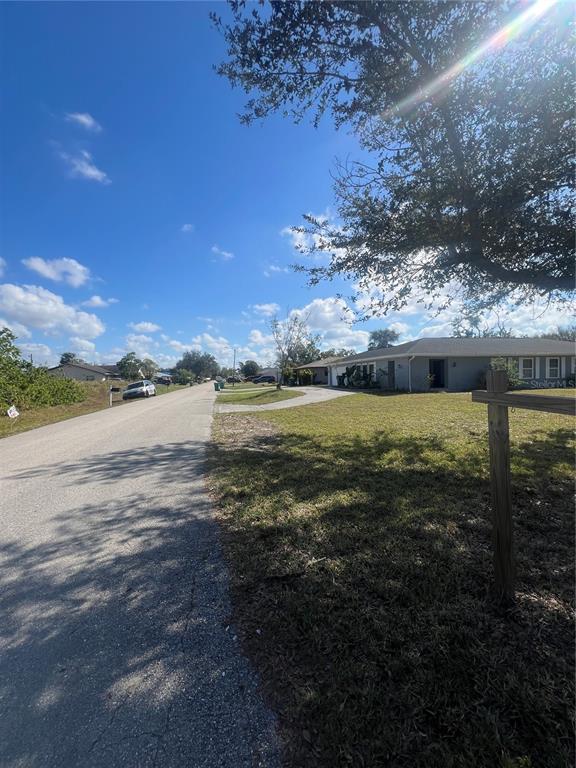 A street view shows a single-story house with a large lawn and a paved road — 22065 MALONE AVENUE, PORT CHARLOTTE, FL