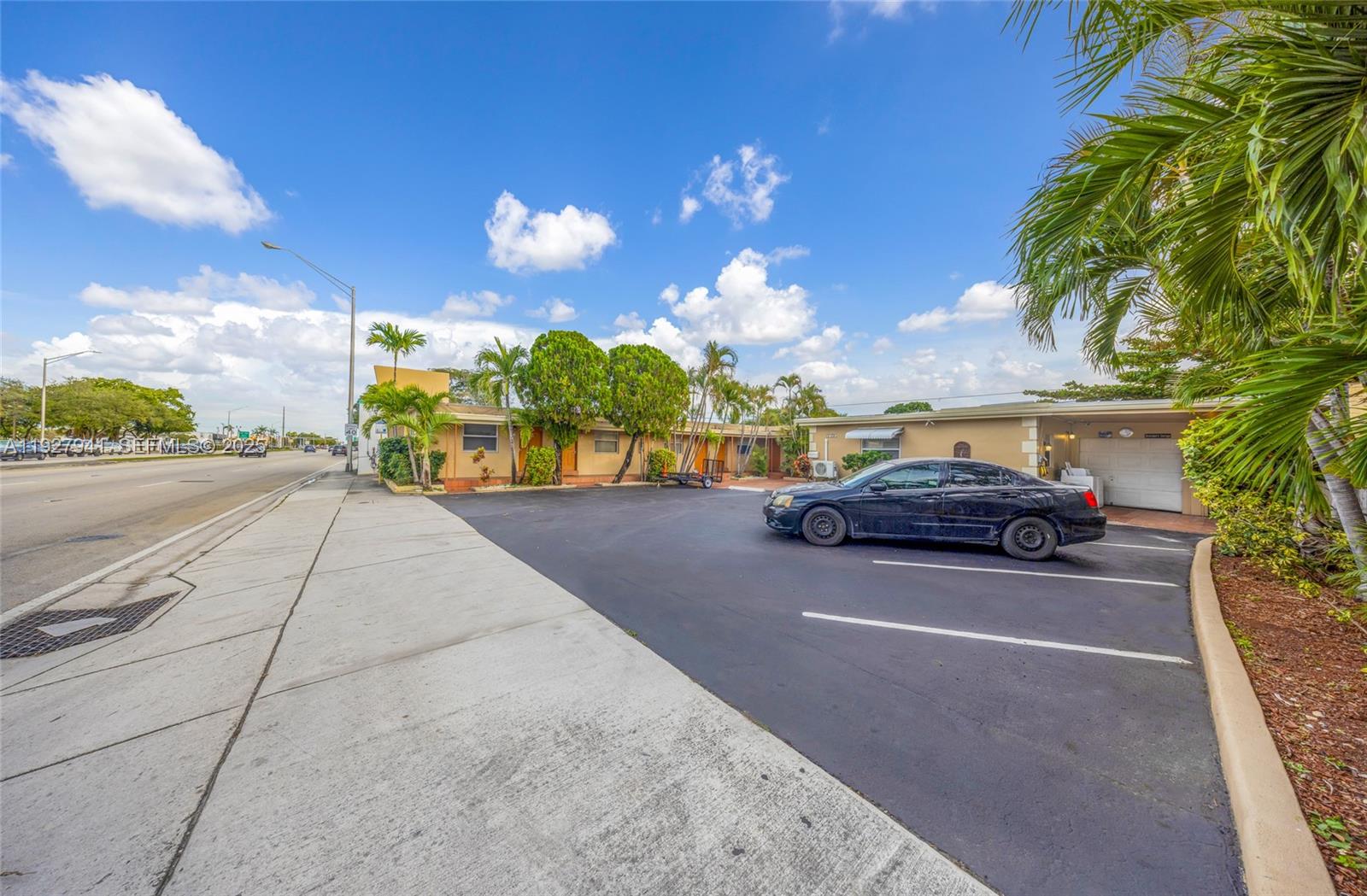 A black sedan is parked in front of a single-story building with a paved lot — 6124 Pembroke Rd # 8, Miramar FL 33023, MIRAMAR, FL
