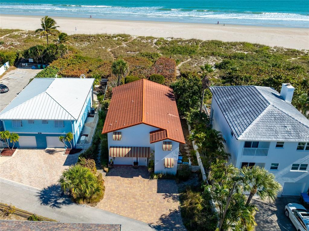 An aerial view shows a house with a red tile roof between two neighboring homes — 8108 PRESIDENTIAL COURT, CAPE CANAVERAL, FL
