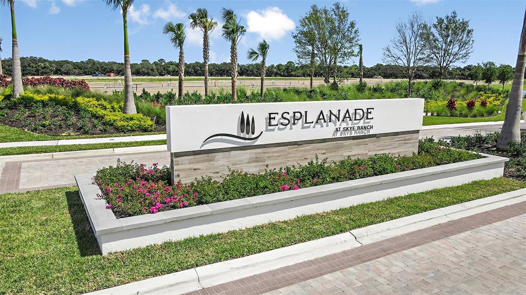 A white monument sign with the text Esplanade at Skye Ranch sits in a landscaped garden — 10573 ECLIPSE STREET, SARASOTA, FL