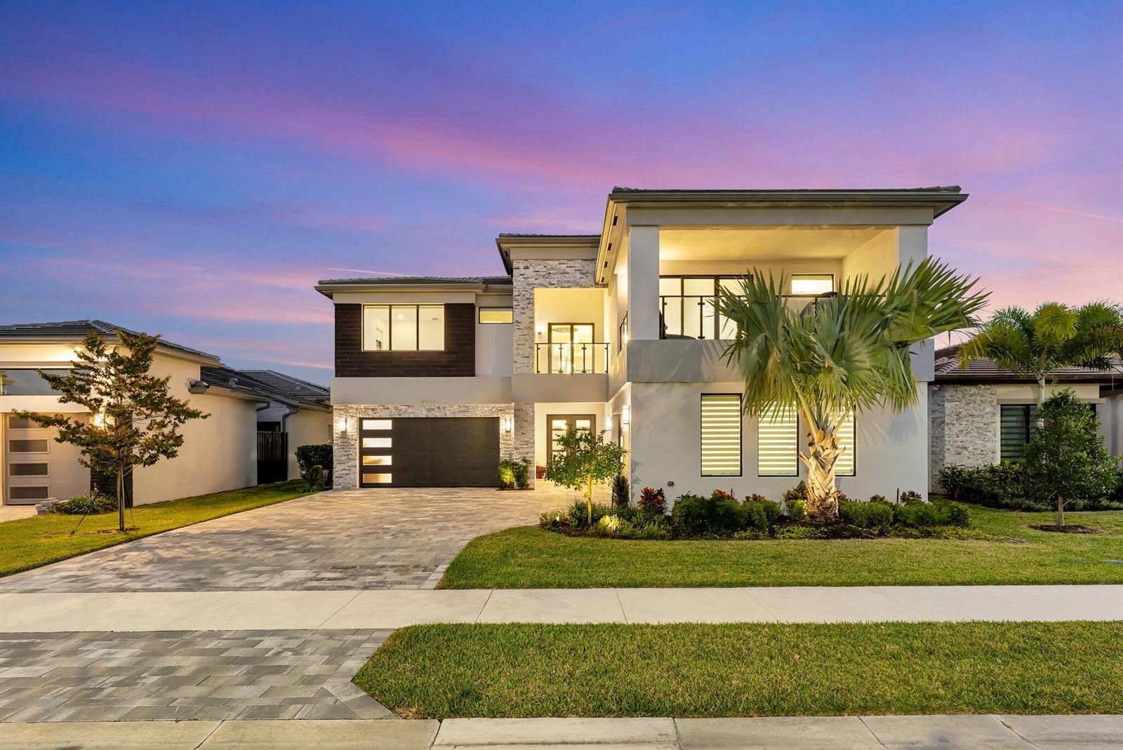 A modern two-story house features a stone facade, a dark garage, and a palm tree — 20046 Pacific Dunes Drive, Boca Raton FL 33434, BOCA RATON, FL