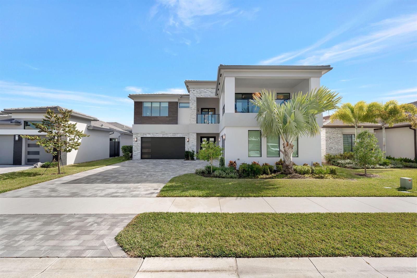 A modern two-story house with a stone facade, a two-car garage, and a balcony — 20046 Pacific Dunes Drive, Boca Raton FL 33434, BOCA RATON, FL