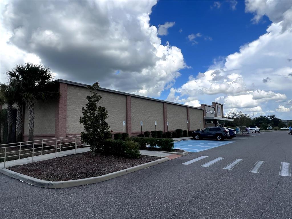 A view of a commercial building exterior with a parking lot and blue-painted handicap spaces — 12249 CORTEZ BOULEVARD, BROOKSVILLE, FL