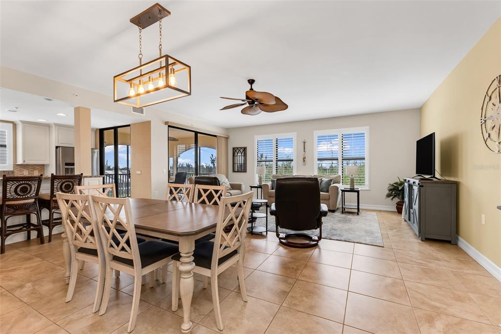 An open-concept living and dining area features tile flooring, a ceiling fan, and pendant lighting — 3340 WOOD THRUSH DRIVE UNIT 241, PUNTA GORDA, FL