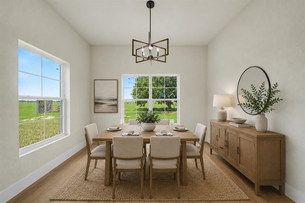 A dining room with a wooden table, chairs, sideboard, and a view of a field — 7159 GOLF CLUB DRIVE, SEBRING, FL