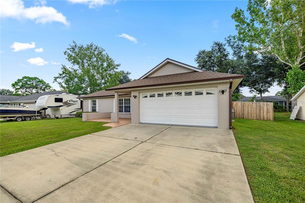 A single-story house with a two-car garage, a concrete driveway, and a parked RV — 36 ALMOND DRIVE, OCALA, FL
