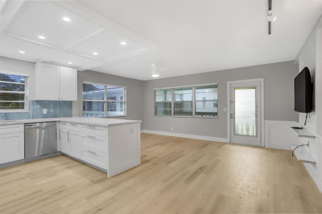 A kitchen and living area featuring white cabinets, a peninsula, and light wood flooring — 40 Prescott B # 40, Deerfield Beach FL 33442, DEERFIELD BEACH, FL