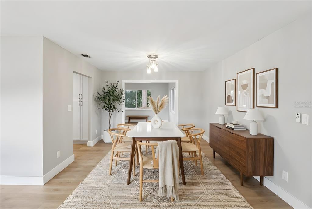 A dining room features a white table, wooden chairs, a sideboard, and a patterned rug — 1412 DIGARMO TERRACE, DELTONA, FL