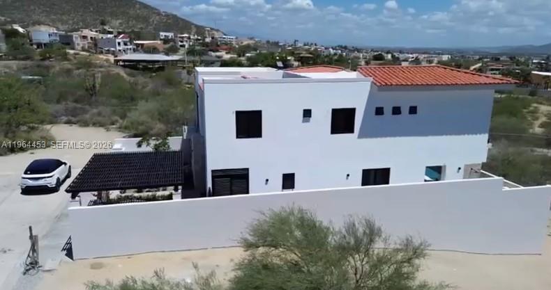 An aerial view shows a two-story white house with a terracotta roof and a pergola — 25 Paséo Vista Hermosa, VA 23405, VA