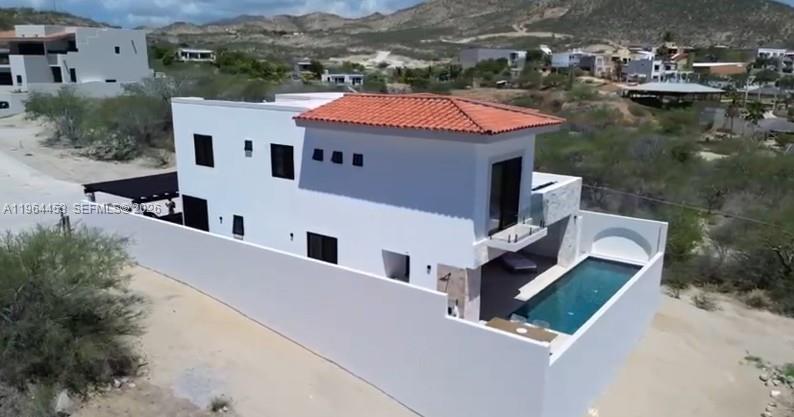 An aerial view of a white two-story house with a red tile roof and pool — 25 Paséo Vista Hermosa, VA 23405, VA