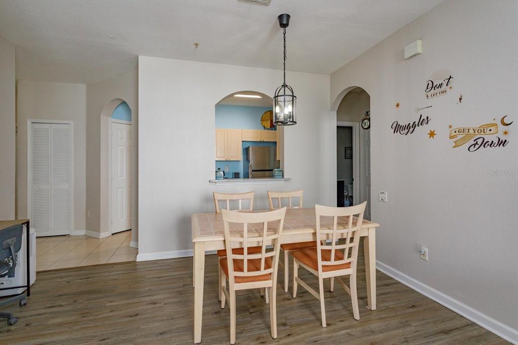 A dining area features a light wood table, four chairs, and a Harry Potter wall decal — 2302 SILVER PALM DR UNIT 204, KISSIMMEE, FL