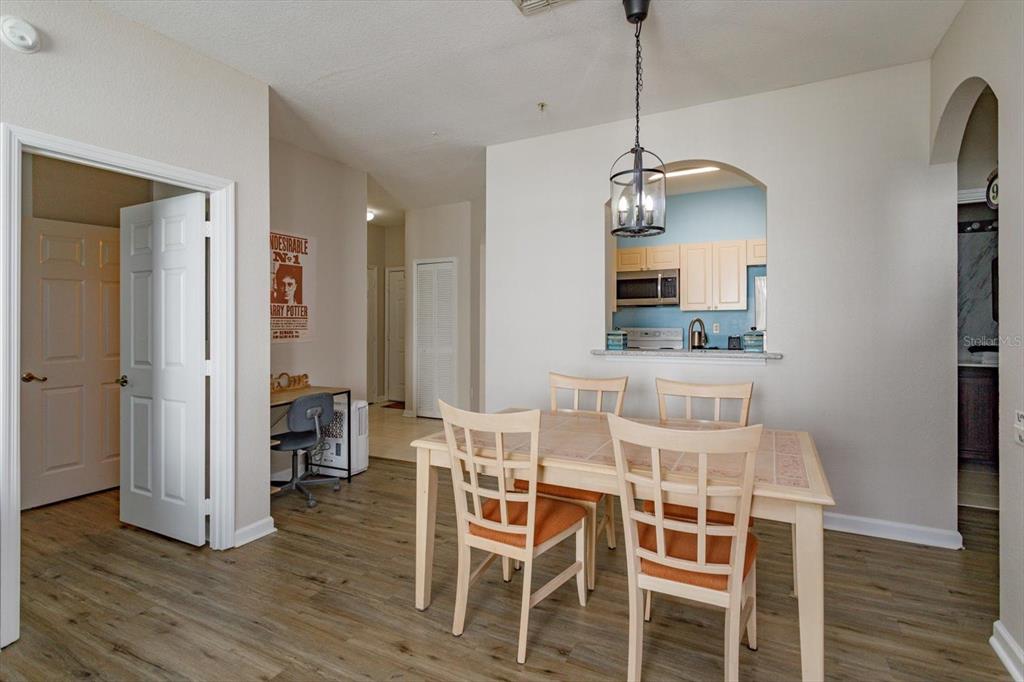 A dining area with a light wood table, four chairs, and a view into the kitchen — 2302 SILVER PALM DR UNIT 204, KISSIMMEE, FL