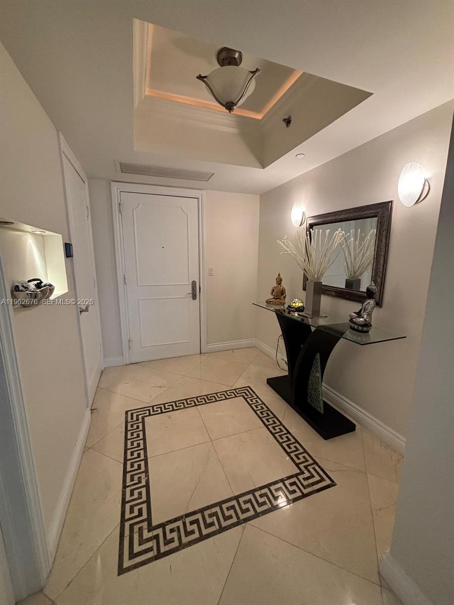 An entryway features a tray ceiling, a glass console table, and a Greek key floor inlay — 1830 S OCEAN DR # 2004, Hallandale Beach FL 33009, HALLANDALE BEACH, FL