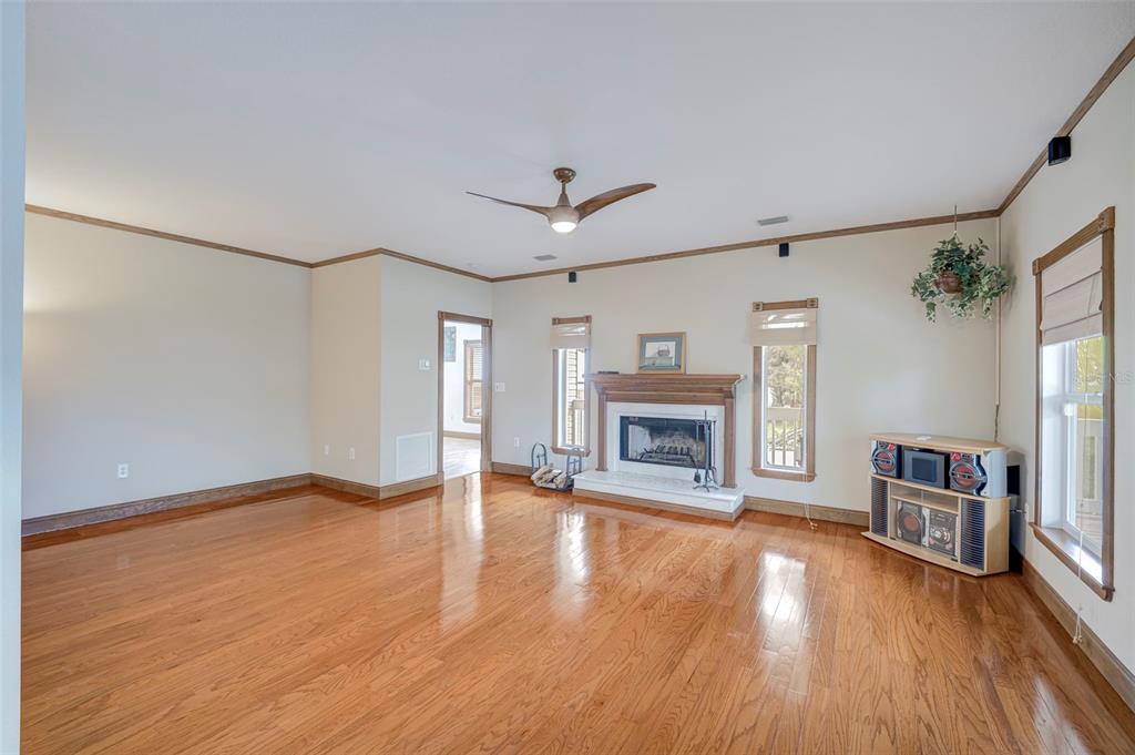 A living room features hardwood floors, a fireplace, and a ceiling fan — 740 W VIRGINIA AVENUE, PUNTA GORDA, FL