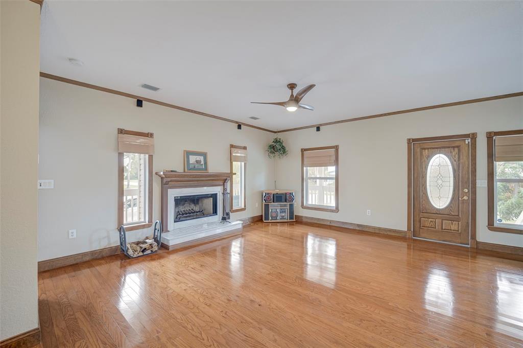 A living room features hardwood floors, a fireplace, a ceiling fan, and an entry door — 740 W VIRGINIA AVENUE, PUNTA GORDA, FL