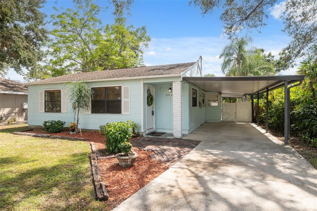 A light blue single-story house with a brick walkway and an attached metal carport — 3918 W FIG STREET, TAMPA, FL
